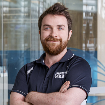 Personal trainer Aidan Galley smiling with arms crossed in front of chest